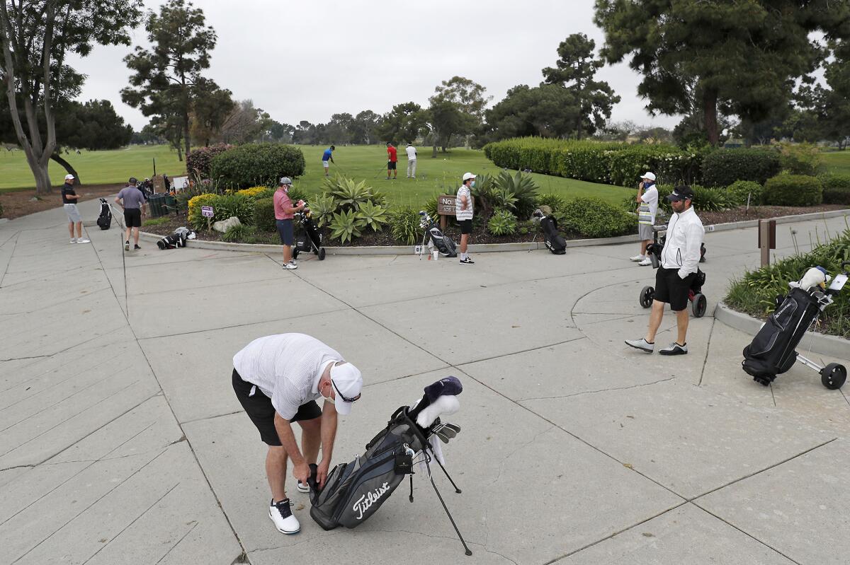 Golfers practice physical distancing as they wait their turn to tee off at Costa Mesa Country Club on Wednesday.