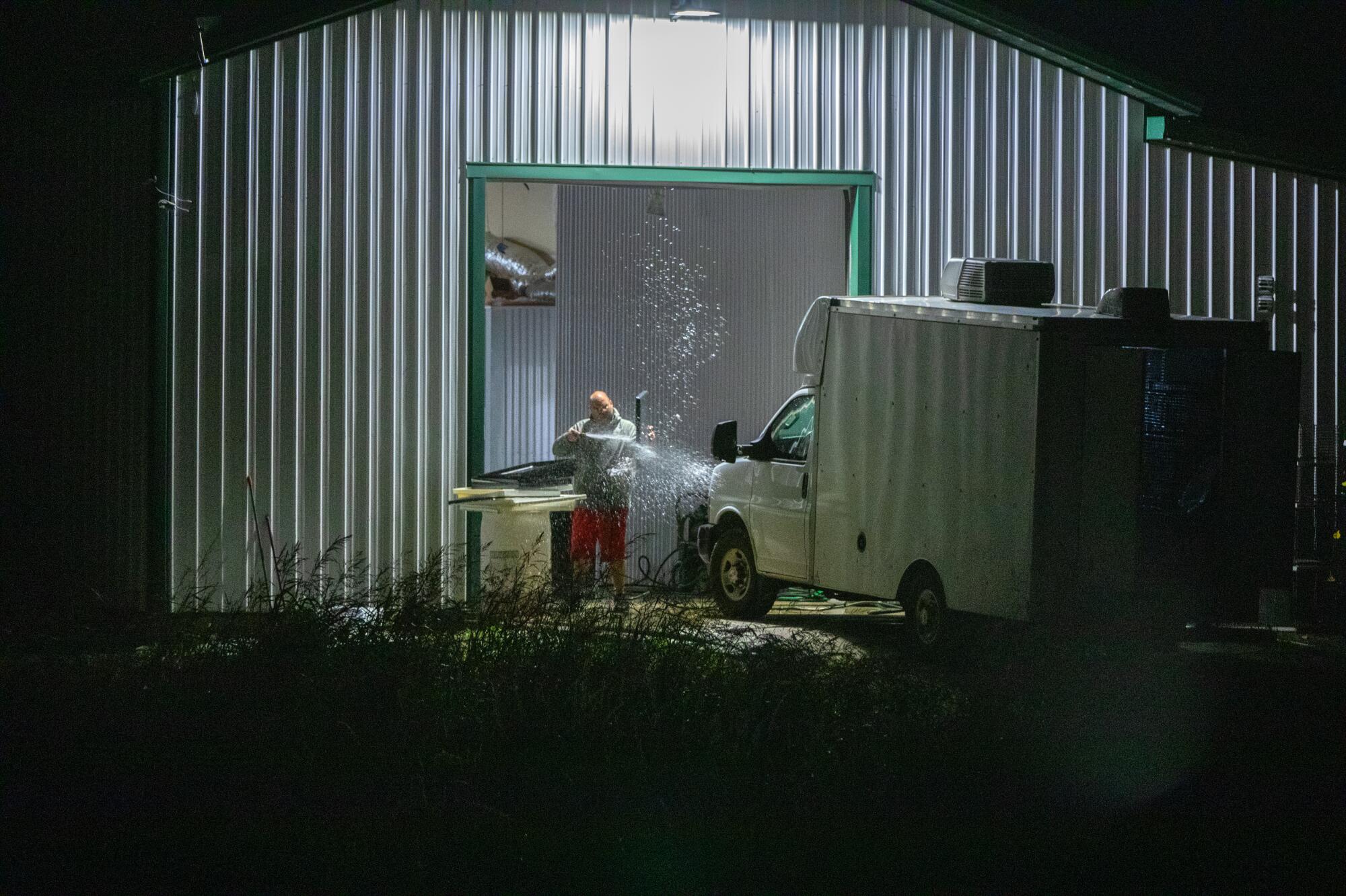 A man cleans equipment outside at a pet transport company in Missouri.