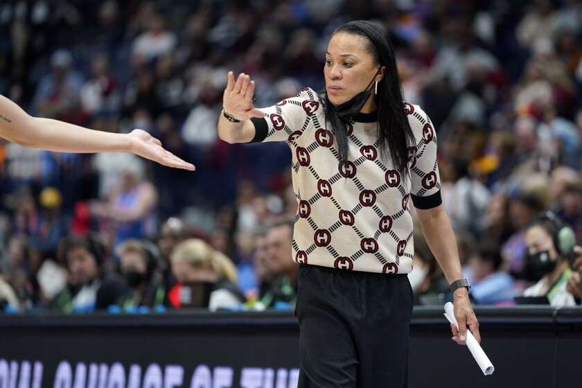 South Carolina head coach Dawn Staley congratulates a player during the second half of an NCAA college basketball semifinal round game against Mississippi at the women's Southeastern Conference tournament Saturday, March 5, 2022, in Nashville, Tenn. South Carolina won 61-51. (AP Photo/Mark Humphrey)