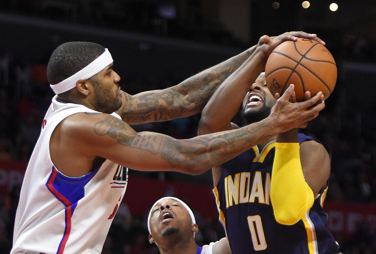 Clippers forward Josh Smith, left, ties up Pacers forward C.J. Miles (0) during the first half.