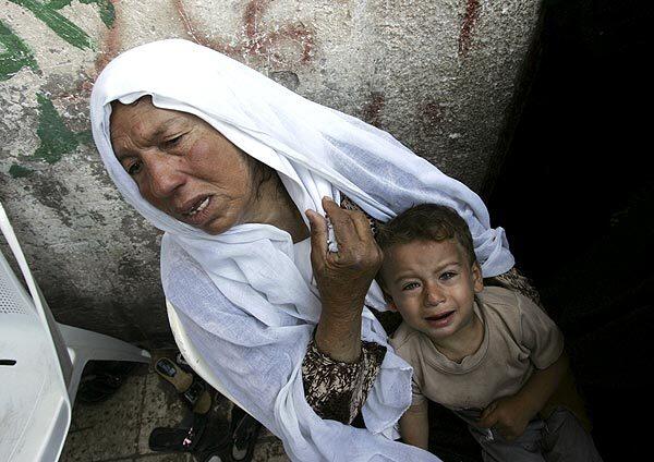 A Palestinian woman and child cry during the funeral of brothers Nael and Mansour Al-Batneji in Rafah, the Gaza Strip. Three brothers from the family were killed in an Israeli airstrike Tuesday on smuggling tunnels from the Gaza Strip to Egypt.