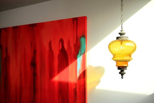 Outside the boys' bedroom, a vintage pendant lamp hangs next to a painting by Los Angeles artist Gary Palmer.