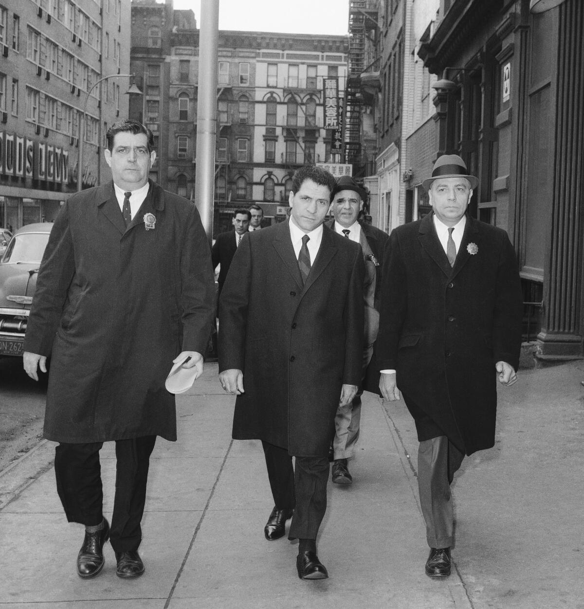 John "Sonny" Franzese, center, is escorted to the Elizabeth Street police station in New York after his arrest on a 43-count gambling indictment.