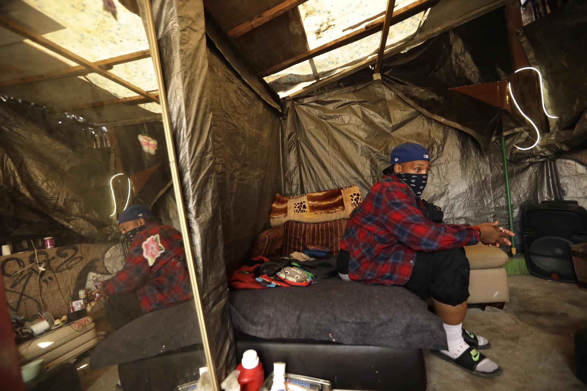 Jaquon Brown lives in a makeshift home that he constructed on the edge of a 10-acre vacant lot in Watts.