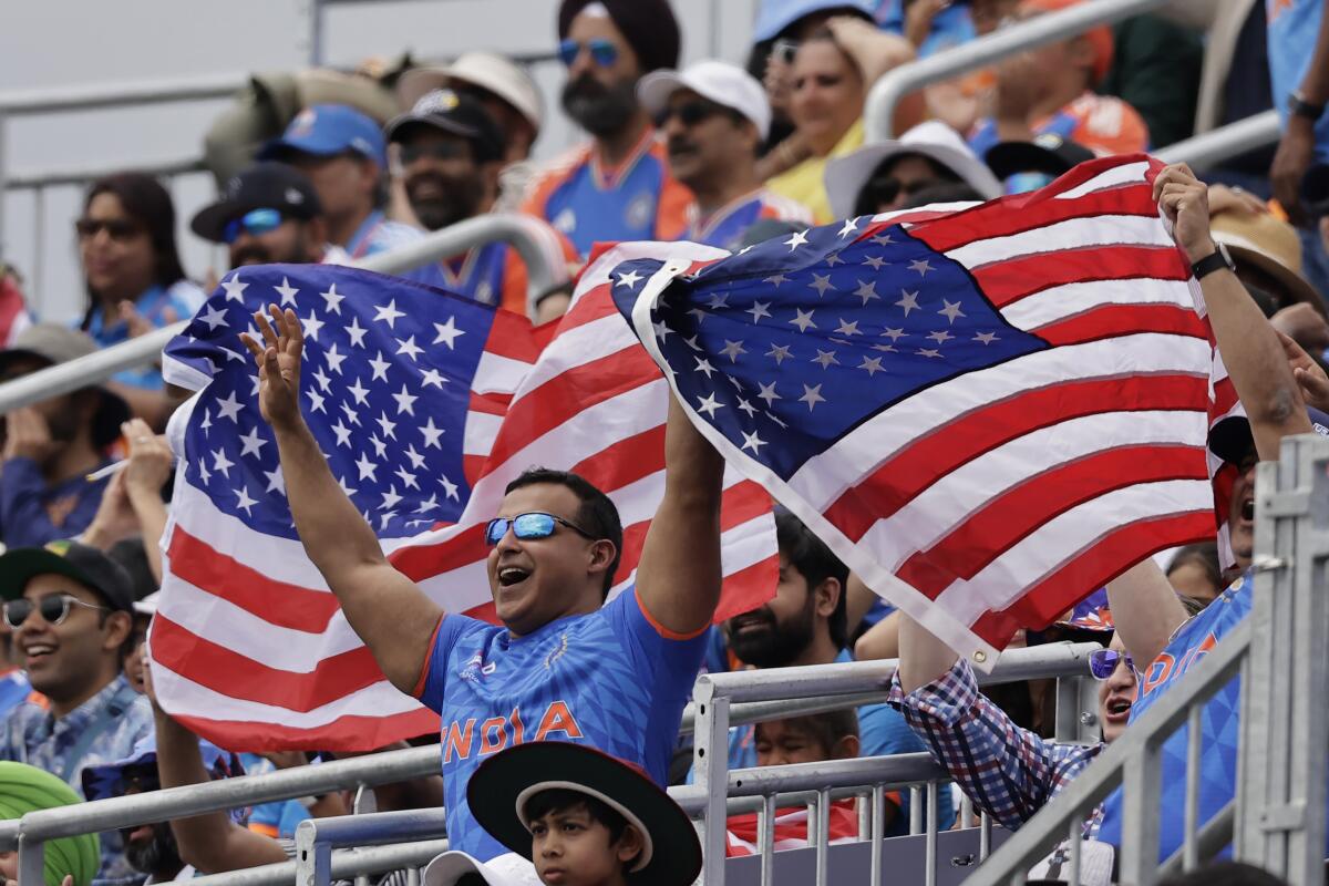 Fans wave U.S. flags during a T20 World Cup cricket match between the U.S. and India in Westbury, N.Y., on June 12.