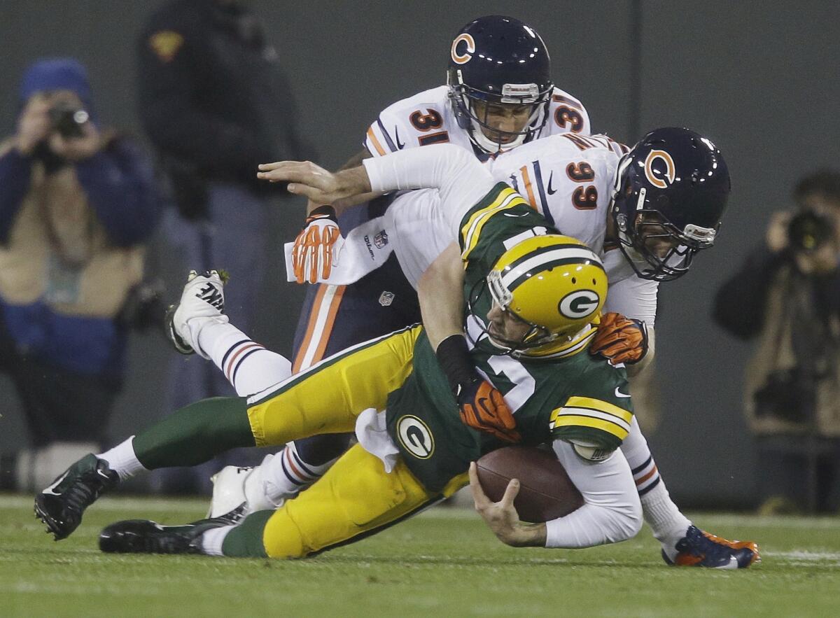 Green Bay quarterback Aaron Rodgers is sacked by Chicago's Shea McClellin, right, and Isaiah Frey during the Bears' win Monday.