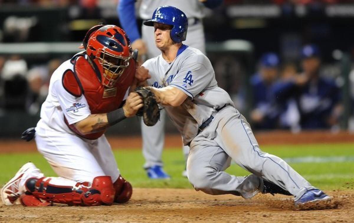 Cardinals catcher Yadier Molina braces for the collision, and appears to fail to apply the tag, as Dodgers second baseman Mark Ellis tries to score on a flyout by Michael Young in the 10th inning of Game 1.