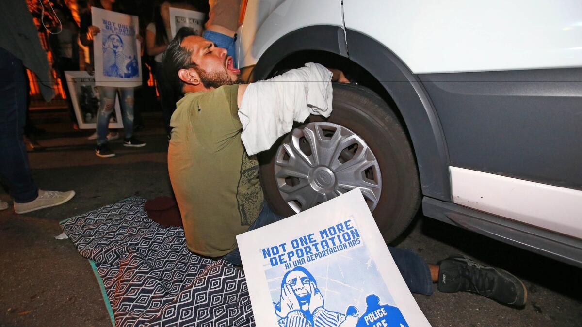 A protester locked himself to the van carrying Guadalupe Garcia de Rayos outside the Immigration and Customs Enforcement field office in Phoenix on Wednesday night.
