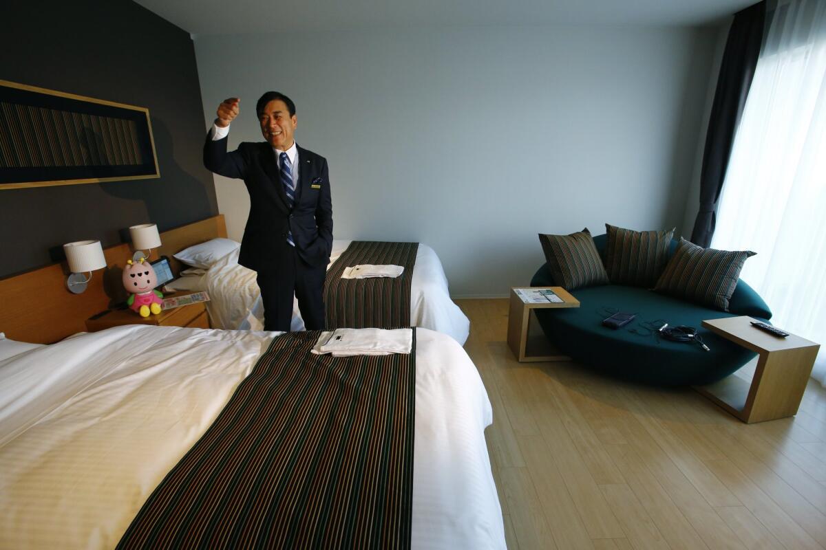 Huis Ten Bosch Co. President Hideo Sawada speaks in a guestroom at the newly opened robot hotel, aptly called Henn na Hotel or Weird Hotel, in Sasebo, southwestern Japan, Wednesday, July 15, 2015. From the receptionist that does the check-in and check-out to the porter that's a stand-on-wheels taking luggage up to the room, the hotel is "manned" almost totally by robots to save labor costs. Sawada, who runs the hotel as part of his amusement park, insists using robots is not a gimmick, but a serious effort to utilize technology and achieve efficiency. (AP Photo/Shizuo Kambayashi)