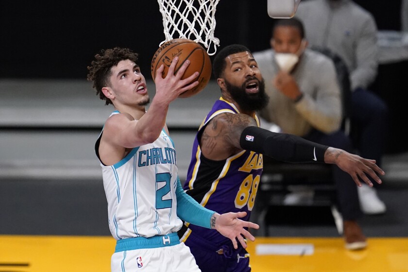 Hornets guard LaMelo Ball scores on a layup against Lakers forward Markieff Morris.
