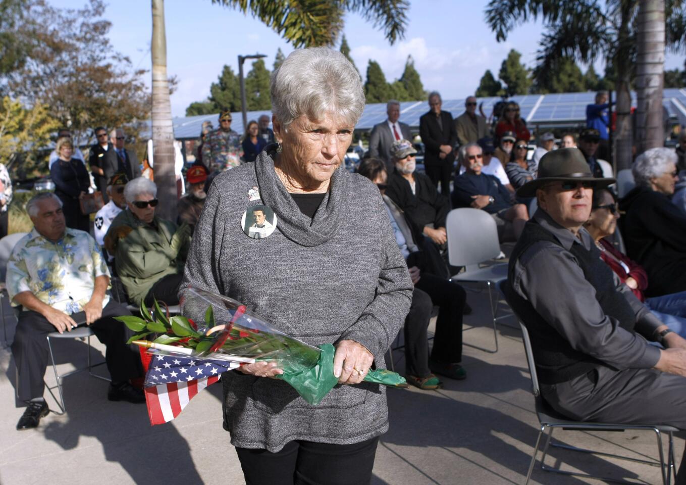 Karen Richardson brought flowers for her father, Ardenne Allen Woodward, who died on Dec. 7, 1941, and placed them at the 75th Anniversary of Pearl Harbor Attack Remembrance Ceremony at the Huntington Beach City Hall Veterans Memorial on Wednesday. Woodward was on the USS Arizona the day the Japanese bombed Pearl Harbor, 75 years ago.