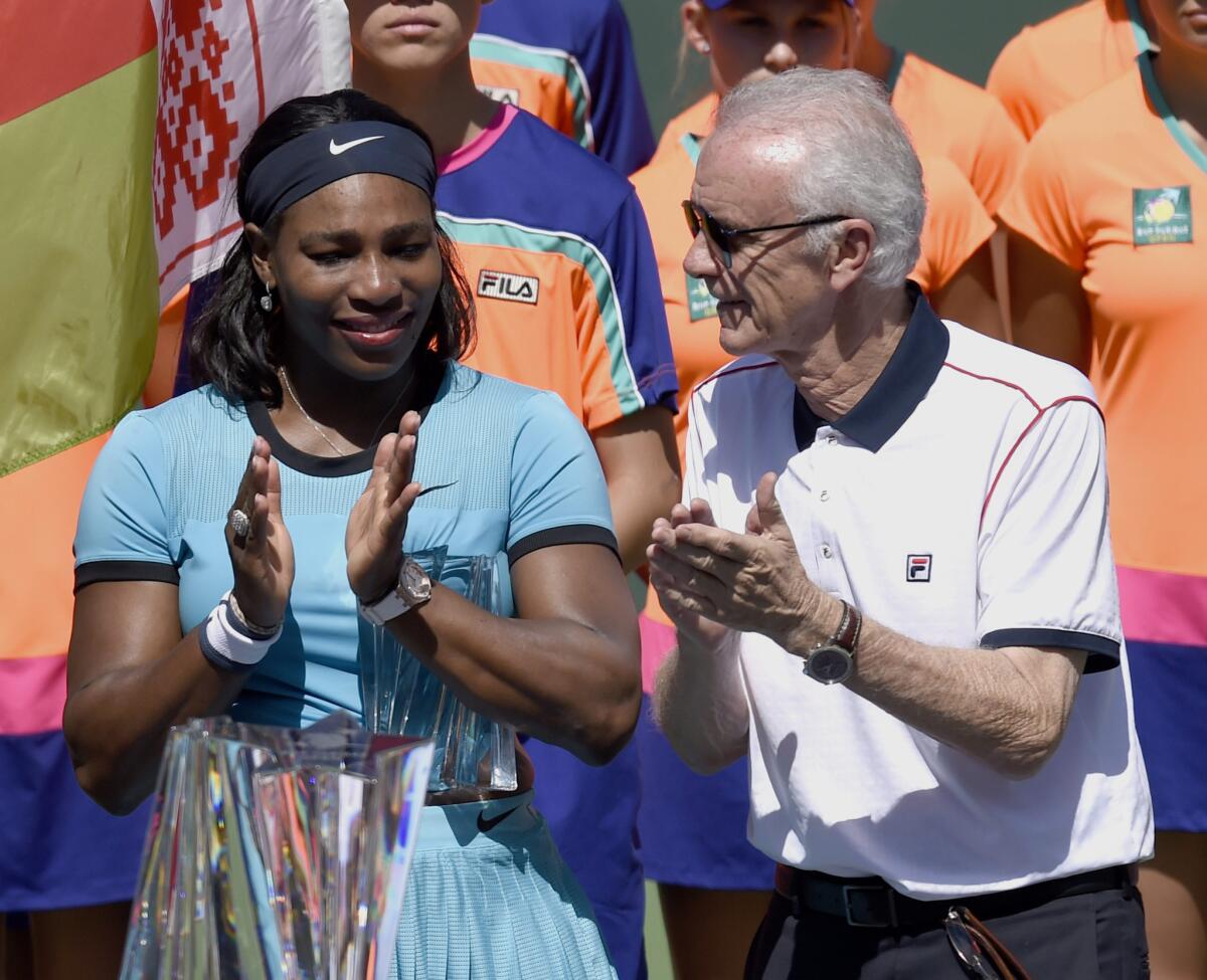 Serena Williams, left, stands with Indian Wells CEO Raymond Moore during the trophy ceremony following the final match against Belarus player Victoria Azarenka.