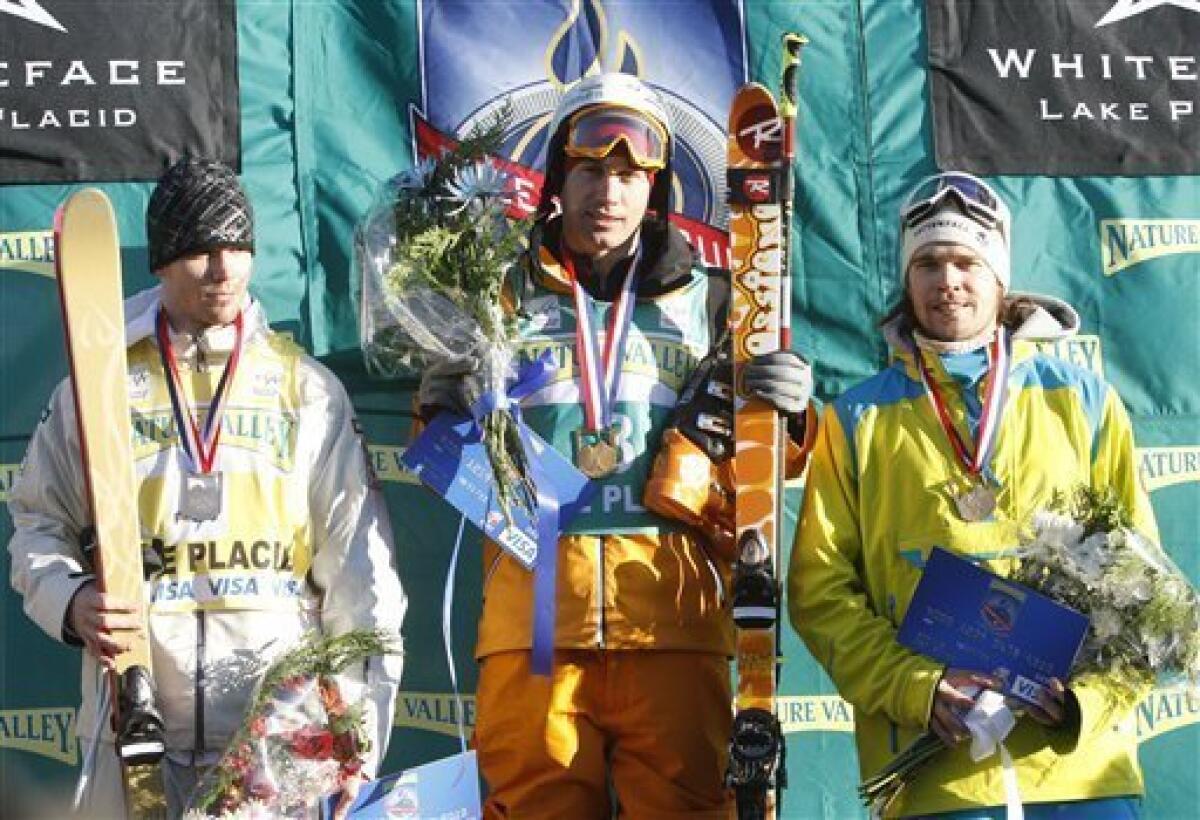 Men's moguls winner Guilbaut Colas, center, of France, center, silver medalist Dale Begg-Smith, left, of Australia, and bronze medalist Jesper Bjoernlund of Sweden, look on from the podium during the medals ceremony at the World Cup freestyle skiing event in Wilmington, N.Y., on Thursday, Jan. 21, 2010. (AP Photo/Mike Groll)