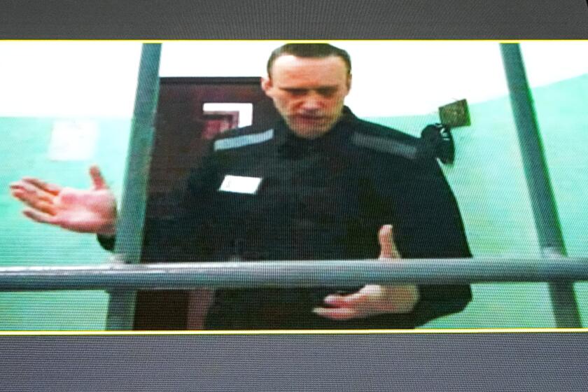 FILE - Russian opposition leader Alexei Navalny is seen on a TV screen as he appears in a video link provided by the Russian Federal Penitentiary Service from the colony in Melekhovo, Vladimir region, during a hearing at the Russian Supreme Court in Moscow, Russia, June 22, 2023. The prosecution has asked the court to sentence imprisoned opposition leader Alexei Navalny to 20 years in prison on extremism charges, his ally Ivan Zhdanov said Thursday July 20, 2023. According to Zhdanov, the trial against Navalny, which went on behind closed doors in the prison where the politician is serving another lengthy sentence, is scheduled to conclude with a verdict on Aug. 4. (AP Photo/Alexander Zemlianichenko, File)