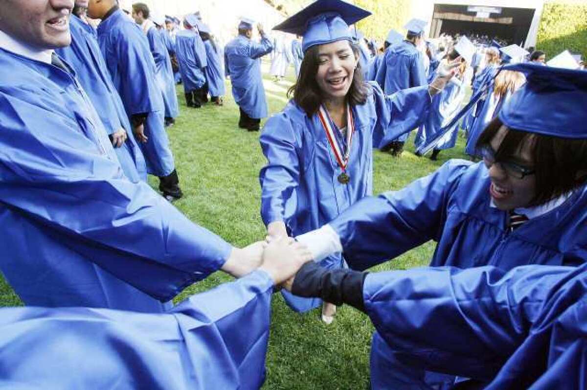 Fridaah Nhuyen, 18, joins friends to cheer as they get ready for graduation at the Starlight Bowl for Burbank High School's graduation.