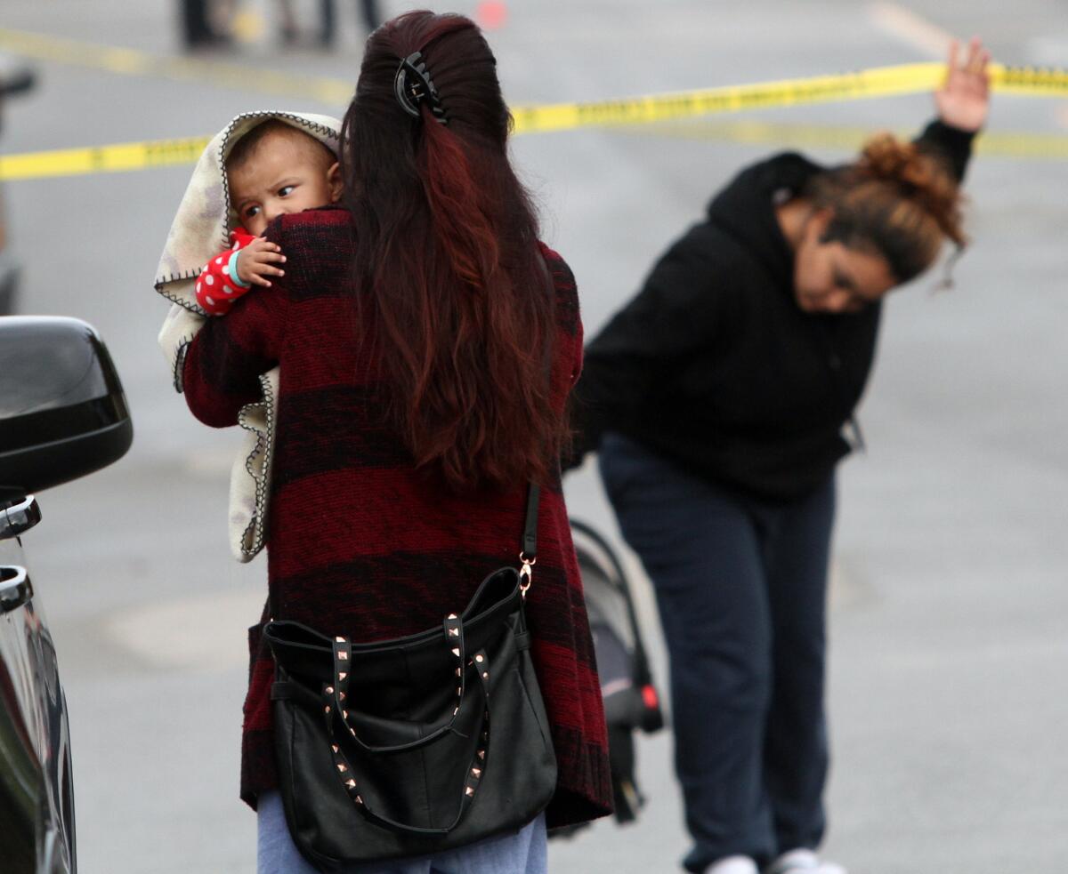 A family member holds an infant who was kidnapped in Long Beach by a man who then led police on a chase in San Pedro.