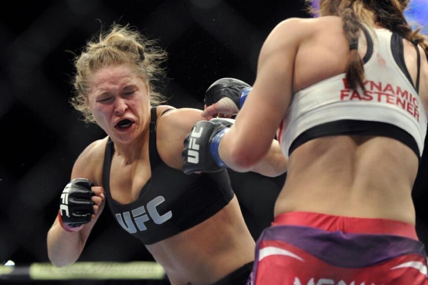 Ronda Rousey, left, punches Miesha Tate during a bout.