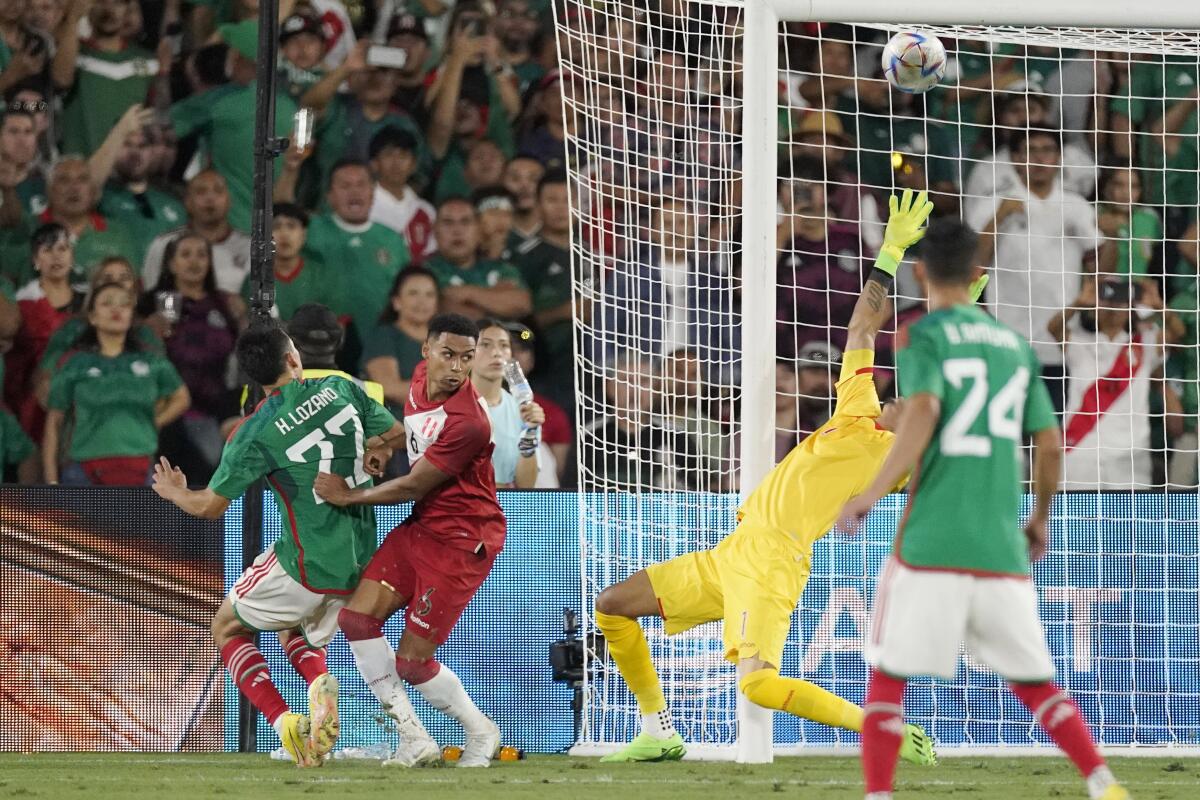 Mexico forward Hirving Lozano, left, scores on