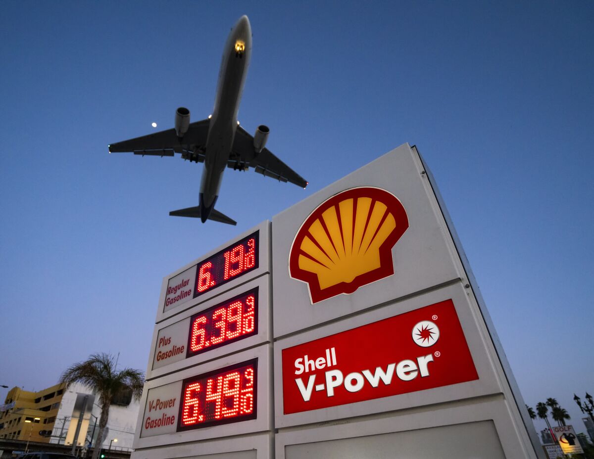 A plane flies over the Shell gas station where gas was $6.19 per gallon for regular Sunday evening in San Diego