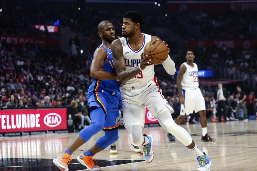 Los Angeles Clippers' Paul George (13) drives against Oklahoma City Thunder's Chris Paul (3) during the first half of an NBA basketball game, Monday, Nov. 18, 2019, in Los Angeles. (AP Photo/Ringo H.W. Chiu)