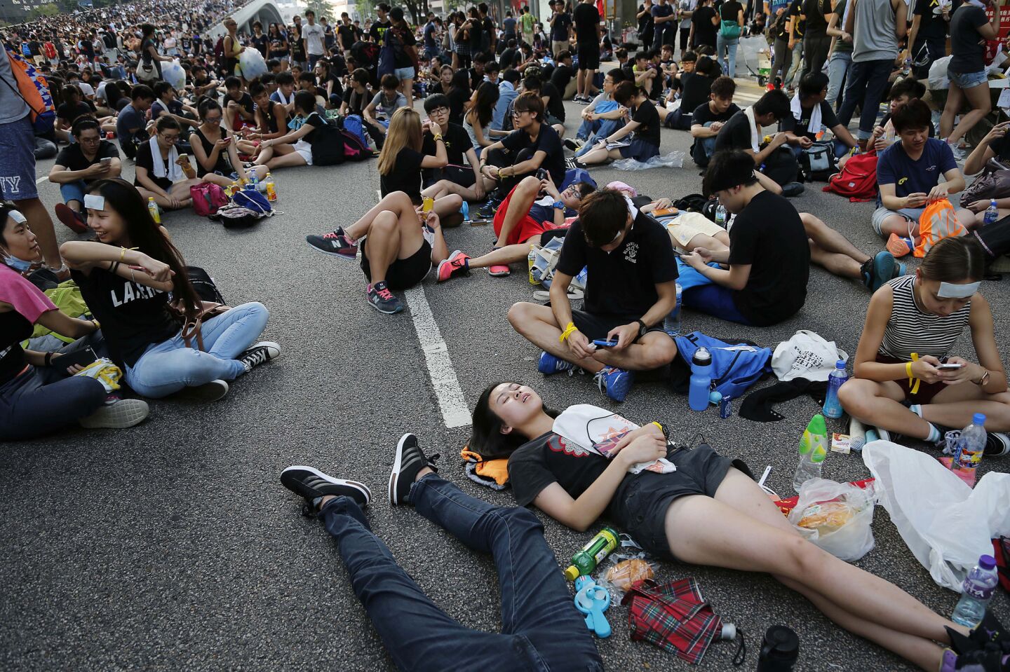 Pro-democracy protesters take afternoon naps on the streets in Hong Kong on Monday.