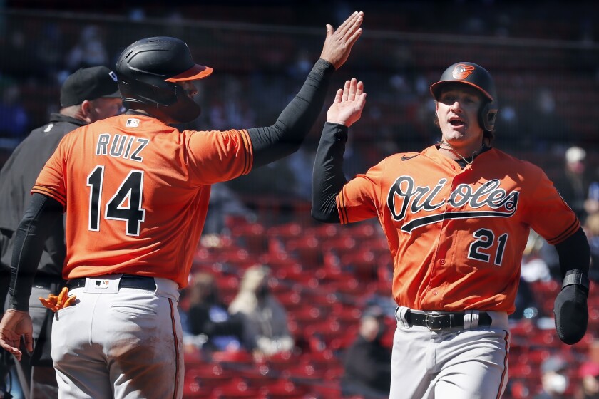 Baltimore Orioles' Rio Ruiz (14) and Austin Hays (21) celebrate after scoring on a two-run single by Maikel Franco during the fourth inning of a baseball game against the Boston Red Sox, Saturday, April 3, 2021, in Boston. (AP Photo/Michael Dwyer)