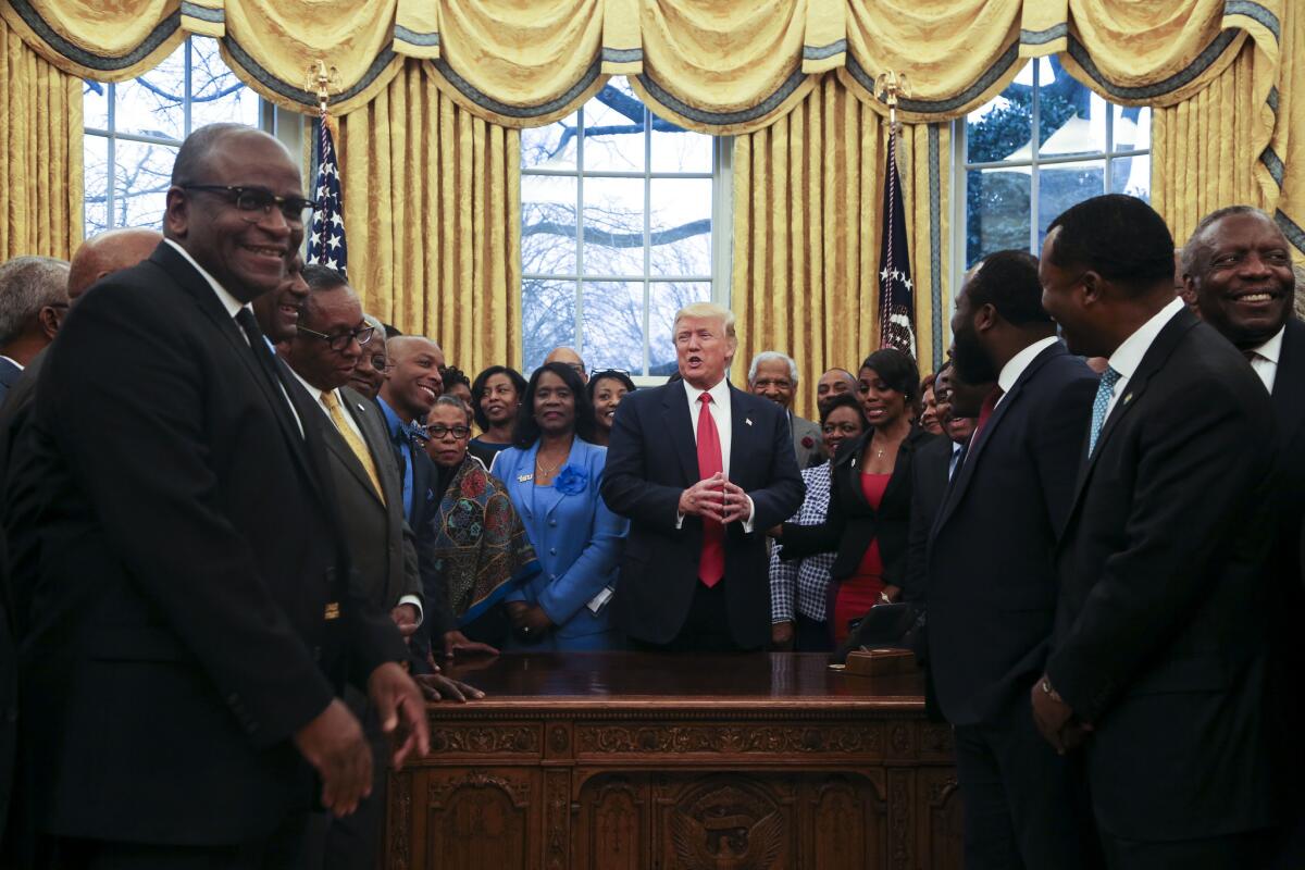 President Trump poses with officials from historically black colleges and universities in the Oval Office in February.