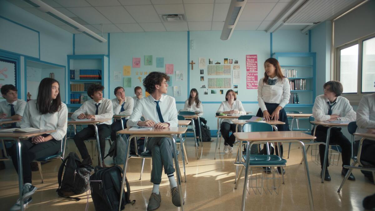 A girl stands to introduce herself to her new Catholic school classmates