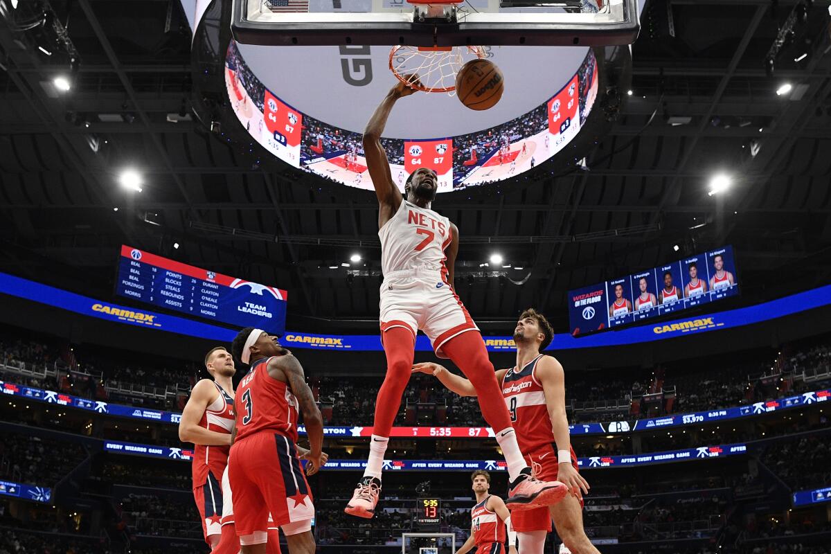 Brooklyn Nets forward Kevin Durant (7) dunks over Washington Wizards guard Bradley Beal (3) and forward Deni Avdija (9) during the second half of an NBA basketball game, Friday, Nov. 4, 2022, in Washington. (AP Photo/Nick Wass)