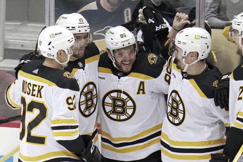 Boston Bruins' David Pastrnak (88) celebrates with teammates after scoring a goal during the second period of an NHL hockey game against the Pittsburgh Penguins in Pittsburgh, Saturday, April 1, 2023. (AP Photo/Gene J. Puskar)