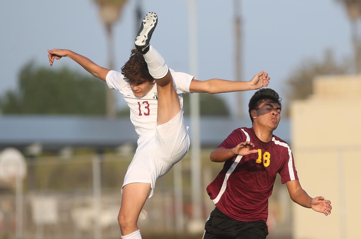 Laguna Beach's Cole Needham (13) gets a leg up on Ocean View's Pablo Martinez as they battle for a throw-in during a nonleague match on Friday in Huntington Beach.