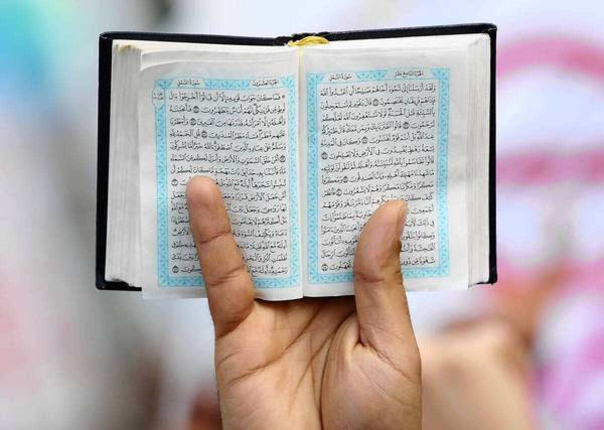 A Koran is held up during a protest last month in Berlin against a right-wing anti-Muslim group.