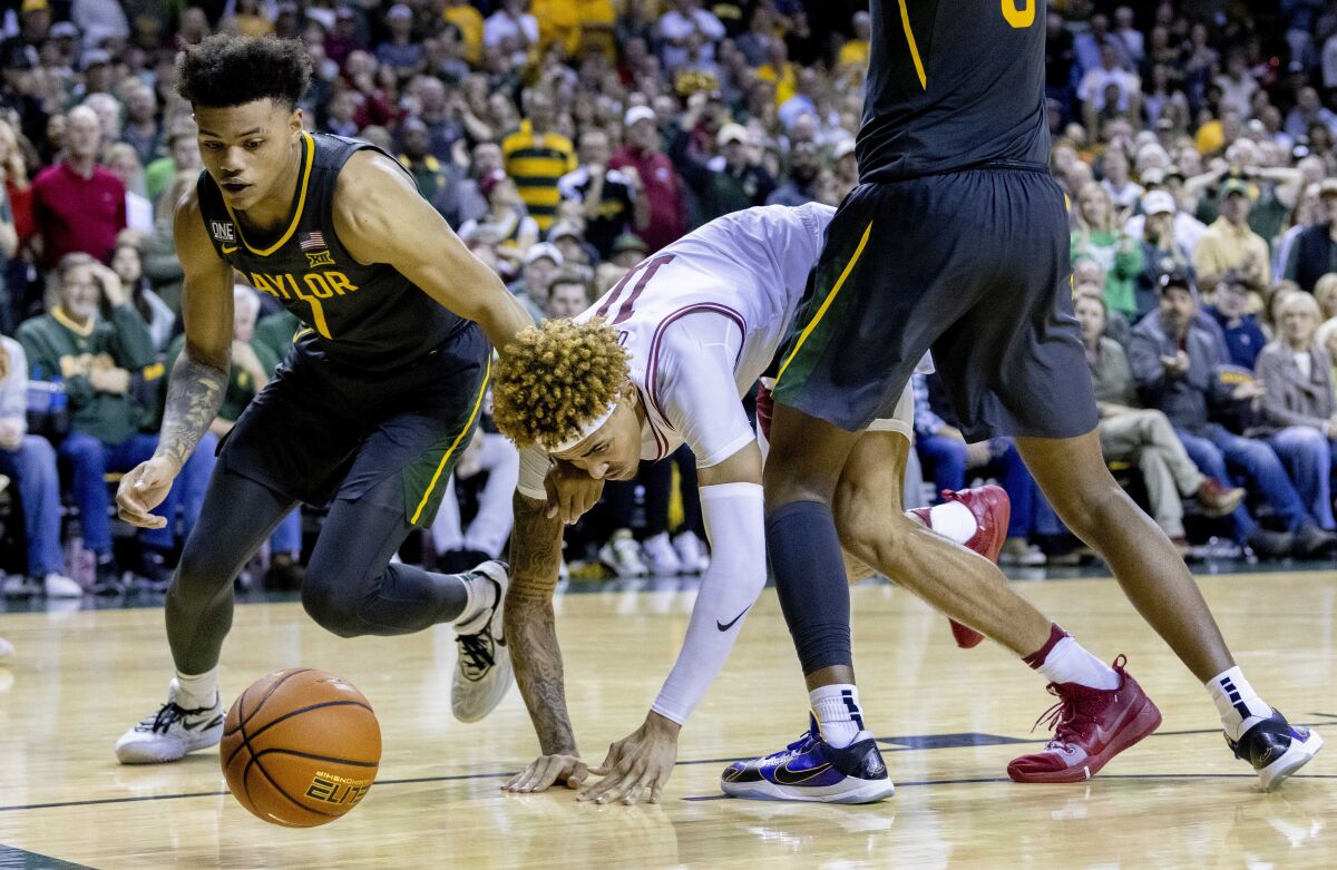 Baylor guard Keyonte George, left, and Arkansas guard Jalen Graham (11) dive for a loose ball during the second half of an NCAA college basketball game in Waco, Texas, Saturday, Jan. 28, 2023. (AP Photo/Gareth Patterson)