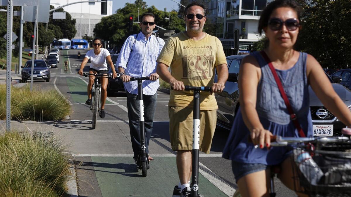 People ride Bird scooters alongside bicycles in Santa Monica in August.