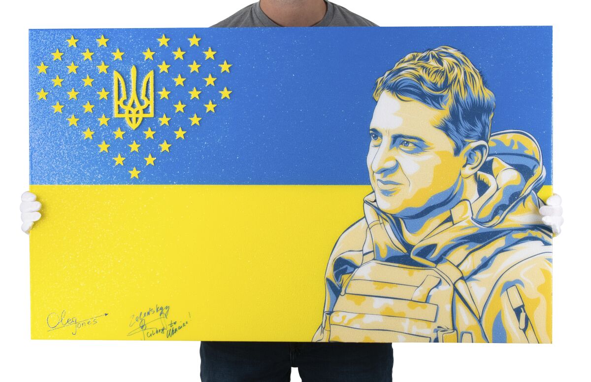 This March 9, 2023, photo provided by RR Auction shows a painting by American artist Oleg Jones of Ukrainian President Volodymyr Zelenskyy that was signed by Zelenskyy. The painting is being sold at auction, which will conclude April 12, 2023, and proceeds from the sale will be used to benefit the nation's people suffering during its war with Russia. (Nikki Brickett/RR Auction via AP)