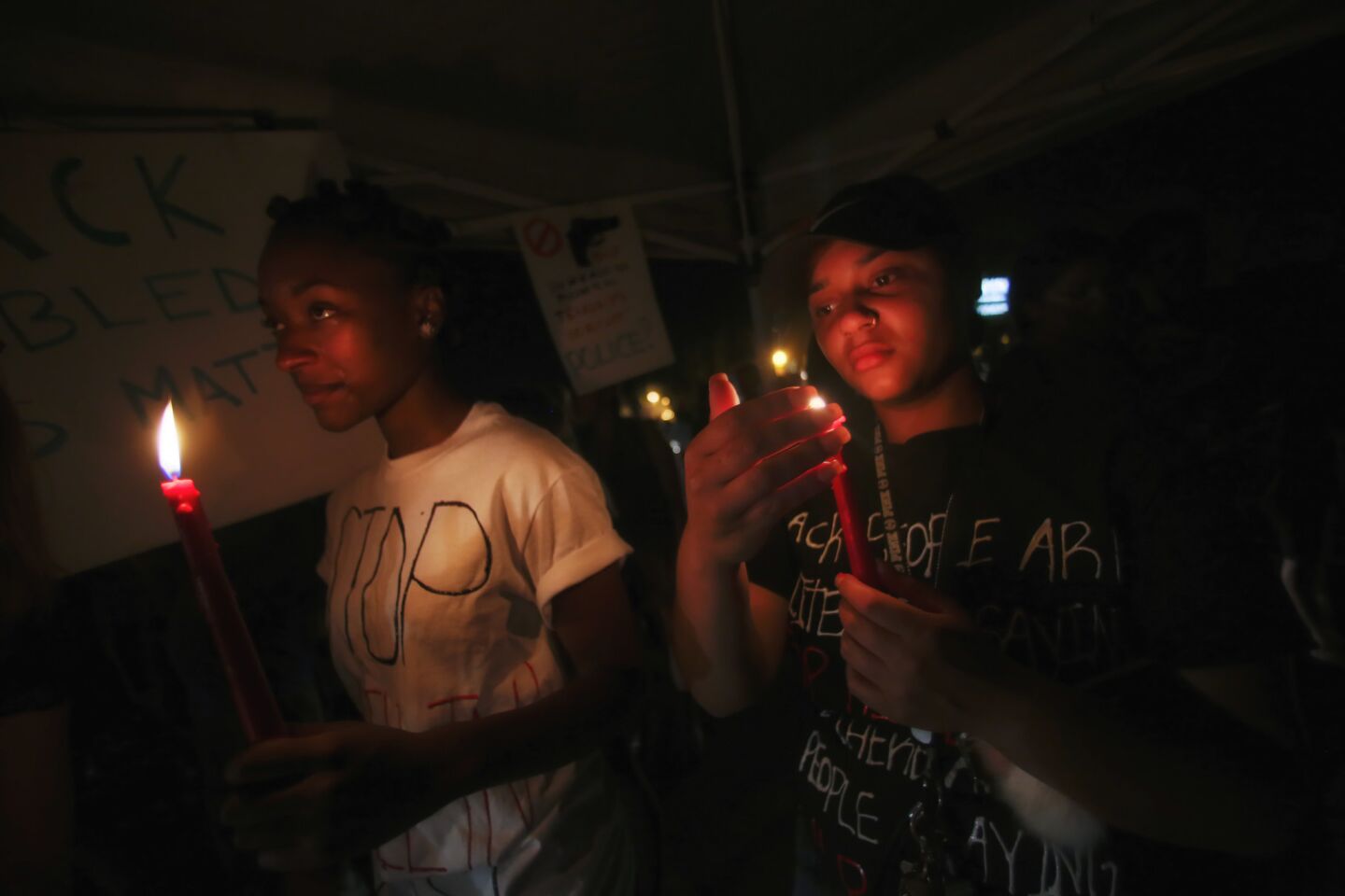 Khadijah Neely, left, and Sabrina Crawford hold a candle during avigil held in El Cajon for Alfred Olango.