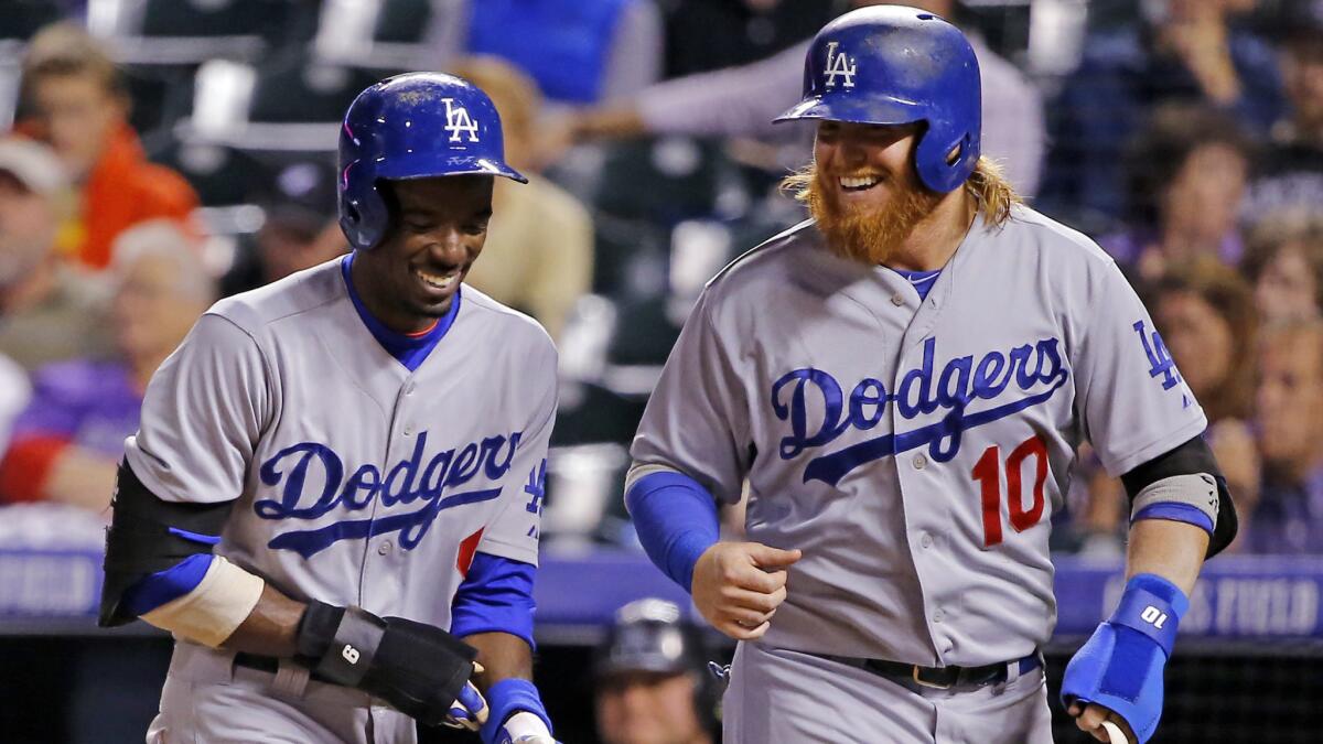 Dodgers teammates Dee Gordon, left, and Justin Turner smile after scoring against the Colorado Rockies on Sept. 15.