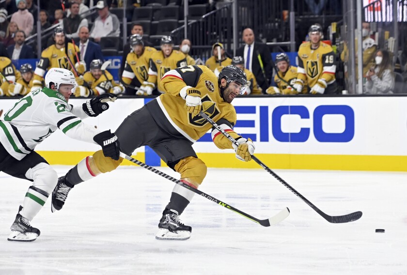 Vegas Golden Knights left wing Max Pacioretty (67) shoots next to Dallas Stars defenseman Ryan Suter (20) during the second period of an NHL hockey game Wednesday, Dec. 8, 2021, in Las Vegas. (AP Photo/David Becker)