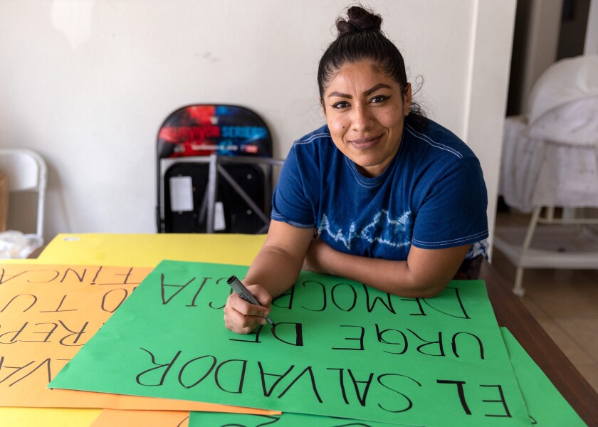 Marta Peinado, una inmigrante salvadoreña, hace carteles de protesta denunciando al presidente de El Salvador, Nayib Bukele.