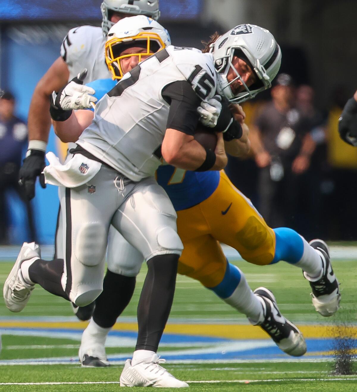 Chargers linebacker Joey Bosa (97) tackles scrambling  Raiders quarterback Gardner Minshew II (15).