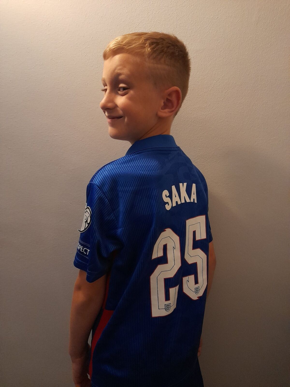 Kai Chapman wears a soccer shirt featuring Bukayo Saka’s number and surname
