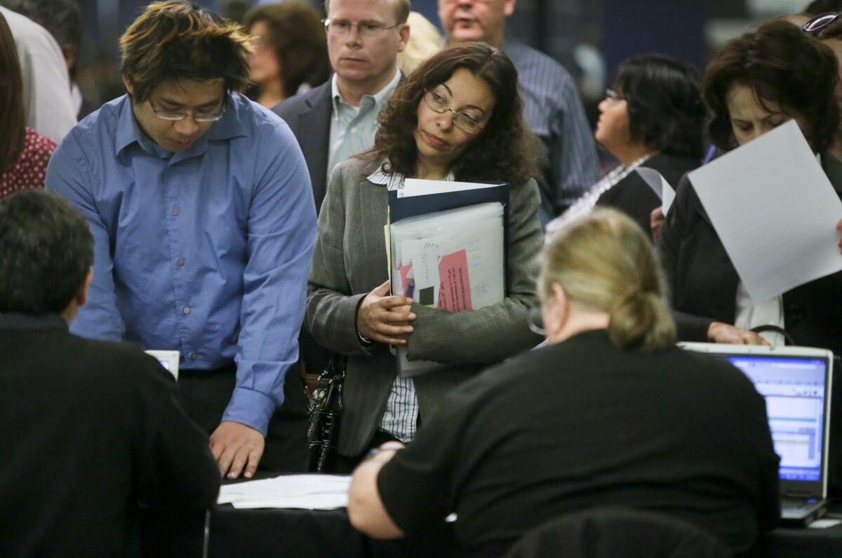 Los Angeles County is poised for a full economic recovery, according to a report by the National Assn. of Counties. Above, job seekers attend a job fair at Angel Stadium in Anaheim.
