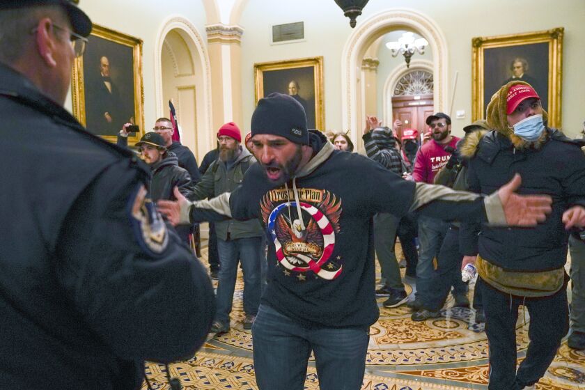 FILE - In this Jan. 6, 2021, photo, Trump supporters, including Douglas Jensen, center, confront U.S. Capitol Police in the hallway outside of the Senate chamber at the Capitol in Washington. The Iowa man was "weaponizing" rioters who joined him in chasing a police officer up a staircase during one of the most harrowing scenes from a mob's attack on the U.S. Capitol, a prosecutor told jurors on Friday, Sept. 23, 2022, at the close of his trial. (AP Photo/Manuel Balce Ceneta, File)