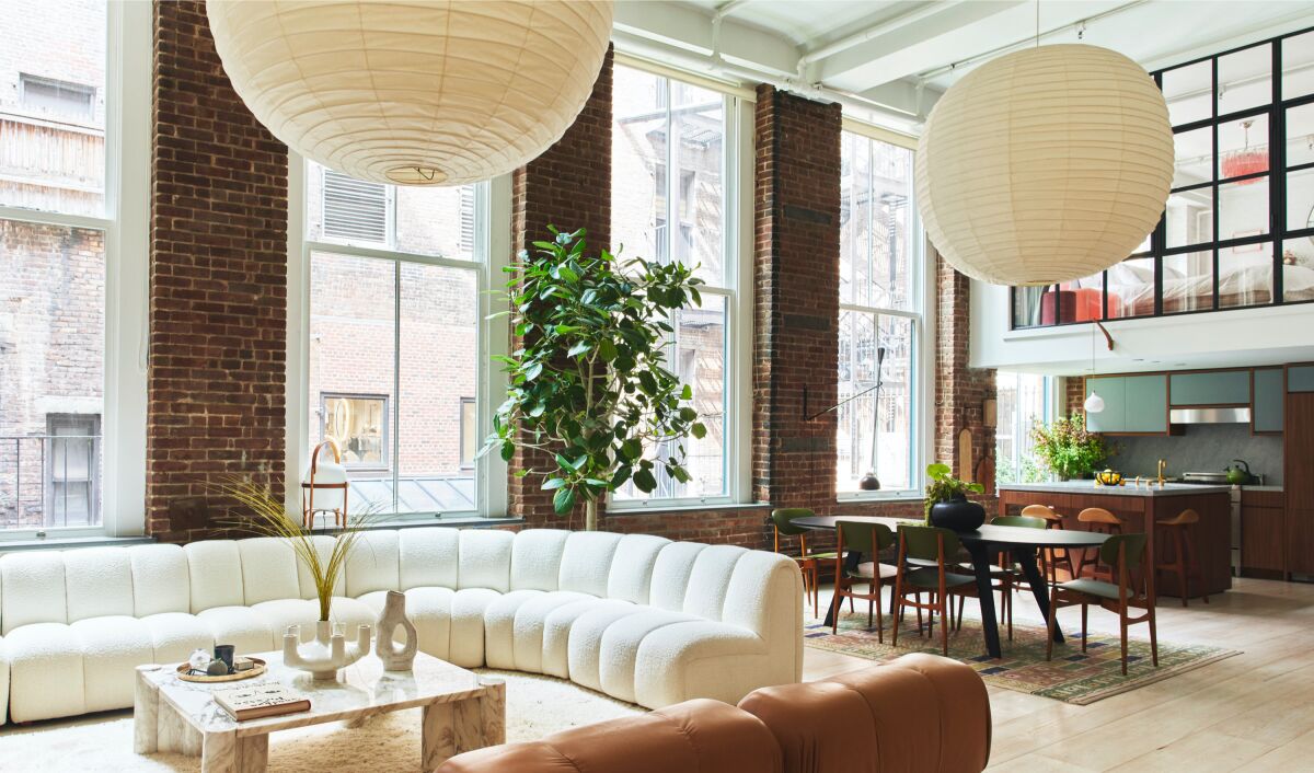 The two-bedroom home features exposed brick walls, original Corinthian columns and a lofted primary suite.