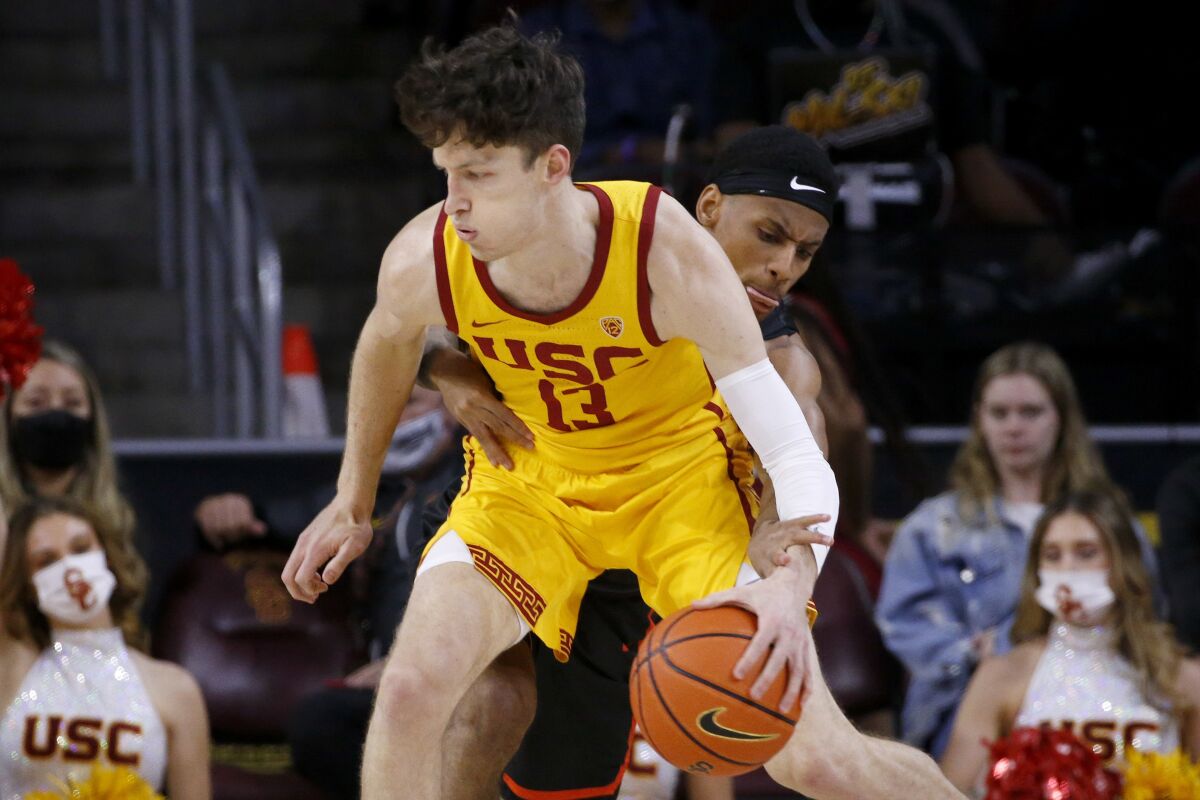 Pacific guard Jaden Byers, back, tries to steal the ball away from Southern California guard Drew Peterson (13) during the first half of an NCAA college basketball game Tuesday, Feb. 8, 2022, in Los Angeles. (AP Photo/Ringo H.W. Chiu)