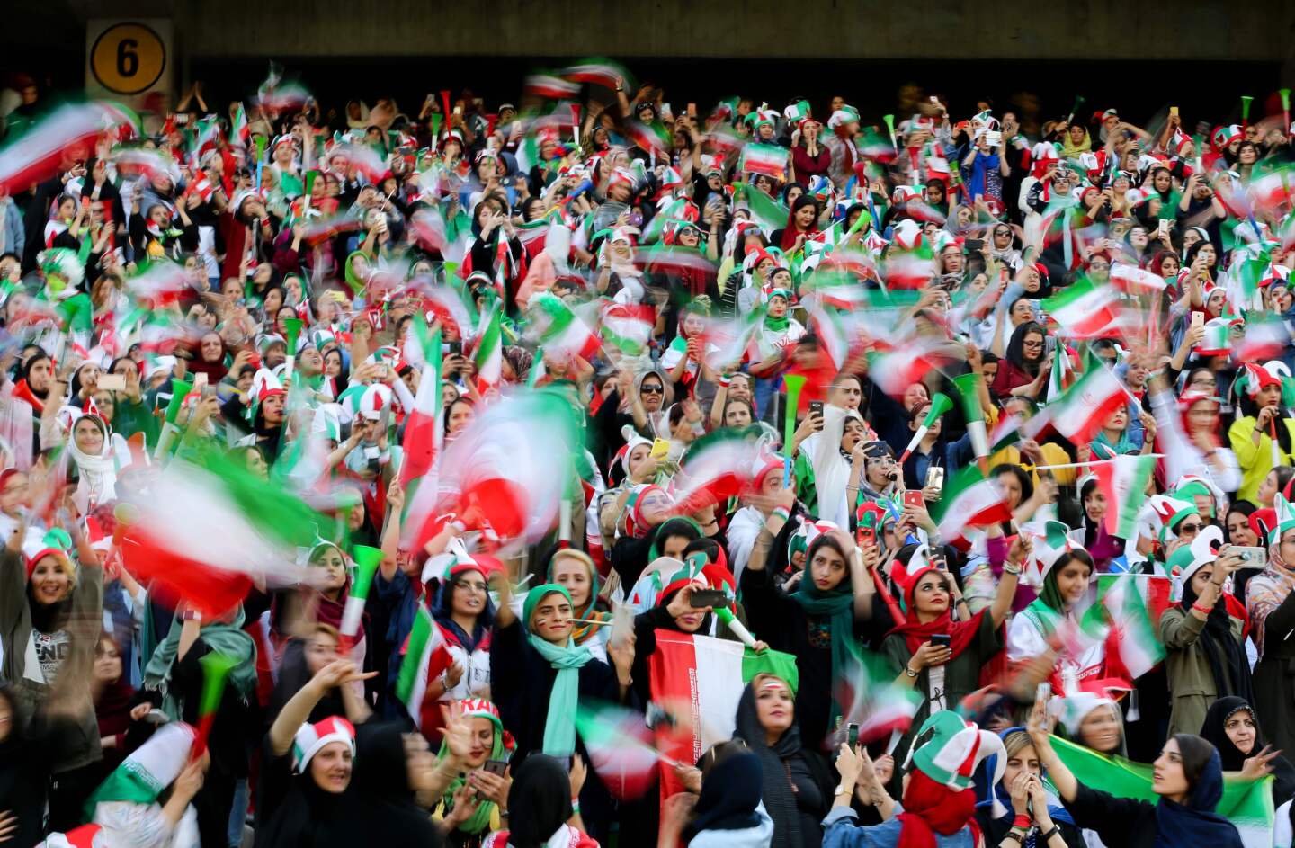 Iranian women cheer during the World Cup Qatar 2022 Group C qualification football match between Iran and Cambodia at the Azadi stadium in the capital Tehran on October 10, 2019. - The Islamic republic has barred female spectators from football and other stadiums for around 40 years, with clerics arguing they must be shielded from the masculine atmosphere and sight of semi-clad men. Women fans are attending the football match freely for the first time in decades, after FIFA threatened to suspend the country over its controversial male-only policy. (Photo by ATTA KENARE / AFP) (Photo by ATTA KENARE/AFP via Getty Images) ** OUTS - ELSENT, FPG, CM - OUTS * NM, PH, VA if sourced by CT, LA or MoD **