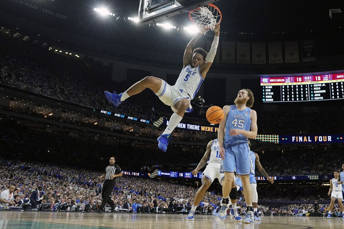 Duke forward Paolo Banchero (5) dunks ahead of North Carolina's Brady Manek (45) during the first half of a college basketball game in the semifinal round of the Men's Final Four NCAA tournament, Saturday, April 2, 2022, in New Orleans. (AP Photo/David J. Phillip)