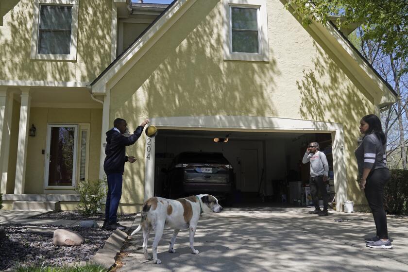 Kia Breaux, right, plays ball with her sons Jaden, 14, left, and John, 17, in front of their home in Kansas City, Mo., Friday, April 21, 2023. The recent shooting of Black teenager Ralph Yarl by an 84-year-old white man when Yarl mistakenly went to the wrong address in a nearby neighborhood, has shaken many Black residents in the predominantly white region of the city. (AP Photo/Charlie Riedel)