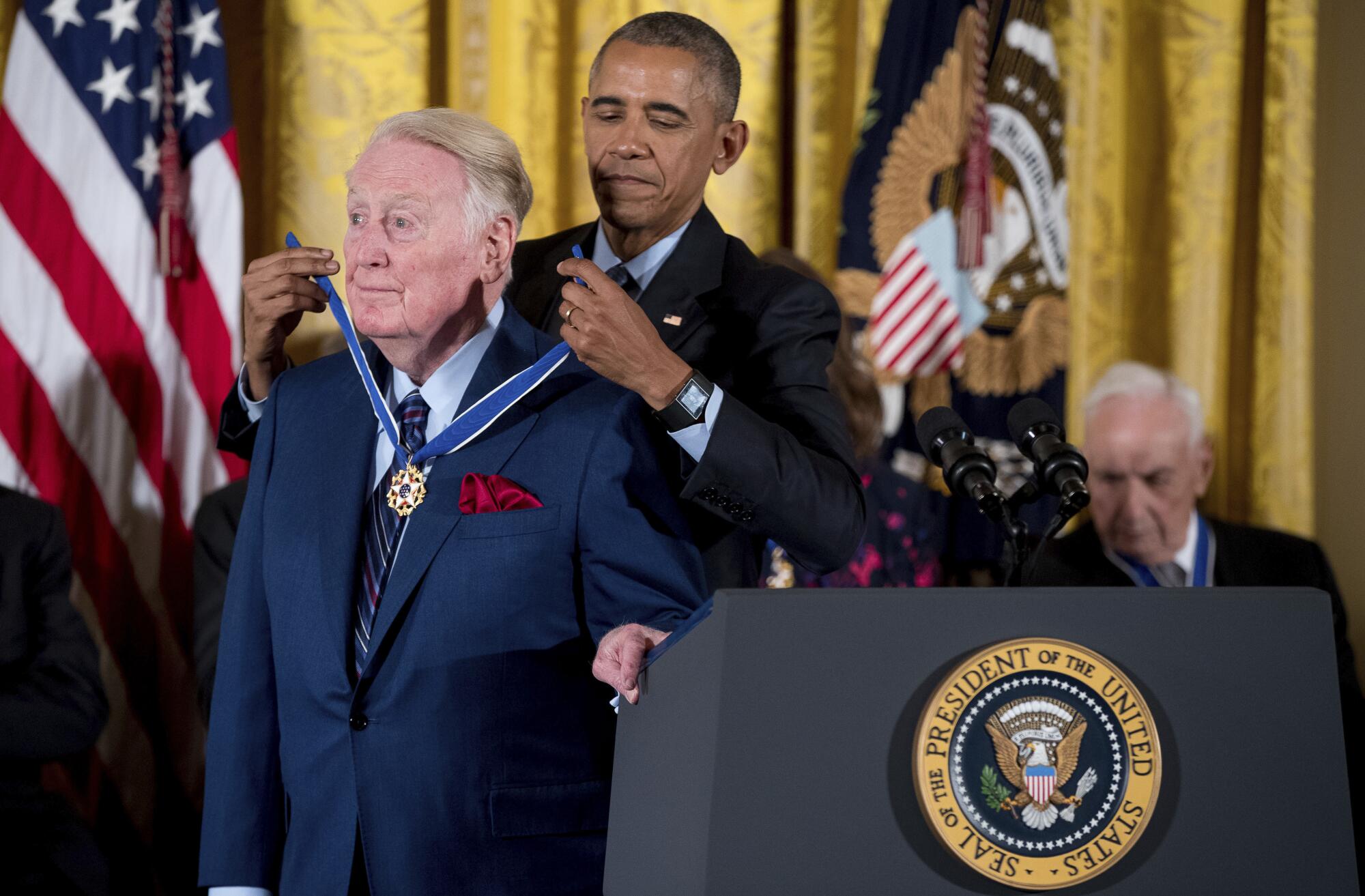 President Barack Obama presents the Presidential Medal of Freedom to Dodgers broadcaster Vin Scully.