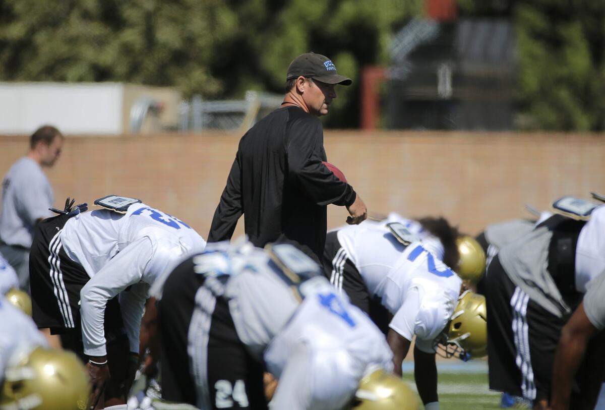 UCLA Coach Jim Mora walks among his players during a practice Wednesday. The Bruins open up their season in Charlottesville, Va. on Aug. 30 against the Virginia Cavaliers.